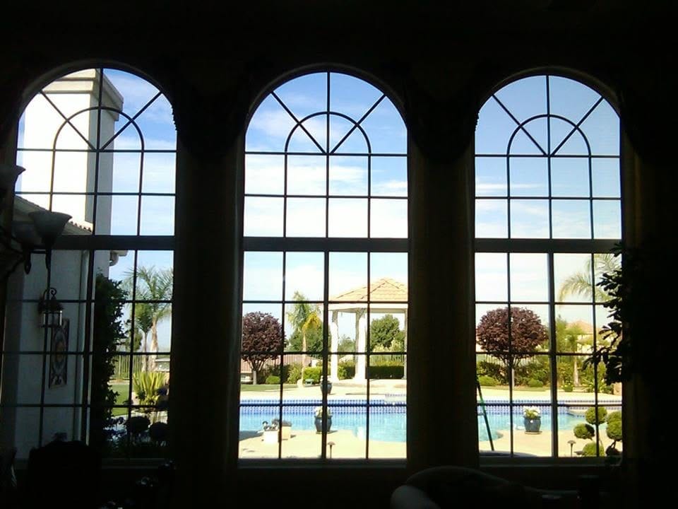 Clean arched windows overlooking a swimming pool and
landscaped yard